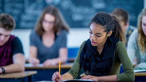 Student Writing In Classroom