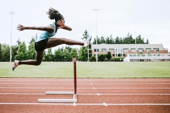 Female athlete hurdling in track and field