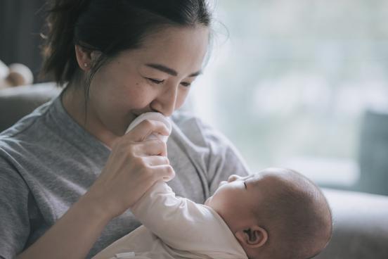 Mother kissing baby's hand