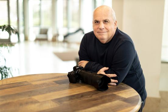 Bob Updegrove sitting at a table with his camera