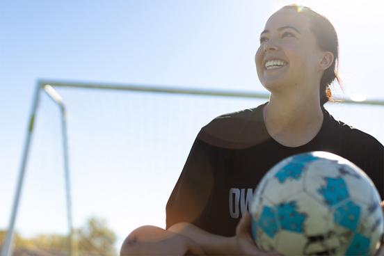 Lainey Armistead sitting with soccer ball