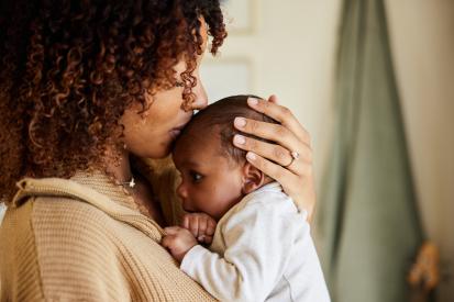 Mother kissing and holding baby