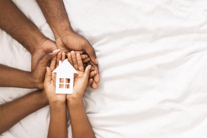 Hands holding a house symbolizing foster care