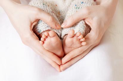 baby feet surrounded by hands shaped like a heart