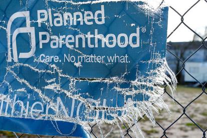 A Planned Parenthood banner on a chain link fence