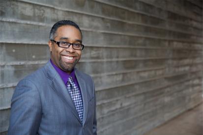 Pastor Esteban Carrasco of Horizon Christian Fellowship in front of a wood wall