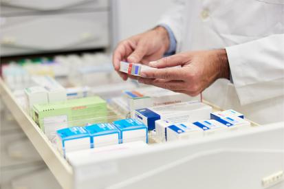 A pharmacist looks at prescriptions in a drawer