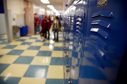 A row of blue lockers lines a school hallway