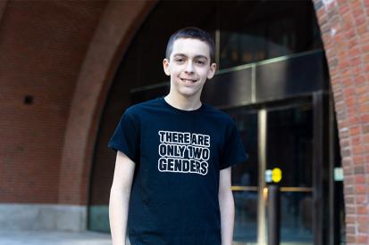 Liam Morrison wearing his "There are only two genders" shirt in front of a courthouse