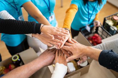 Volunteers put their hands together for a charity project