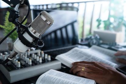 A microphone and Bible sit on a broadcaster's desk