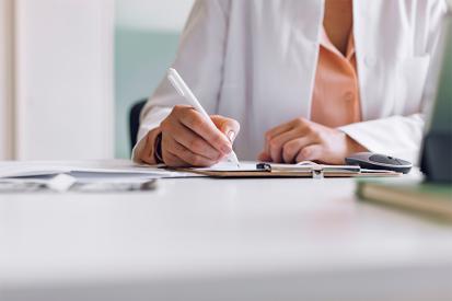 A doctor writes notes on a document