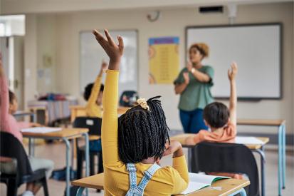 Students raise their hands to answer a question in class