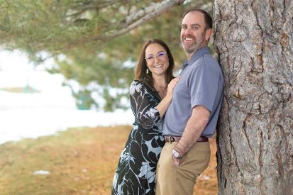 Joe and Serena Wailes smile as they lean against a tree