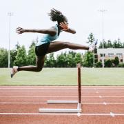 Female athlete hurdling in track and field