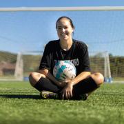 Lainey Armistead sitting with soccer ball