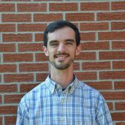 John Kluge in front of a brick wall