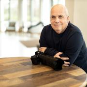 Bob Updegrove sitting at a table with his camera