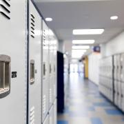 Lockers are seen lining an empty school hallway