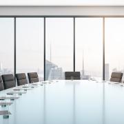 Board Room with notes and glasses overlooking city skyline