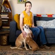 Jessica Bates sits on the couch with her dogs