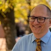 French teacher Peter Vlaming is seen standing outside smiling in the sun