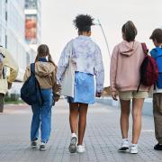 Kids walking on the sidewalk with backpacks