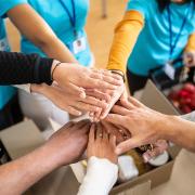 Volunteers put their hands together for a charity project