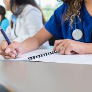 Medical student writing in a notebook