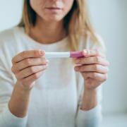 A woman looks down at a pregnancy test