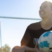 Lainey Armistead sitting with soccer ball