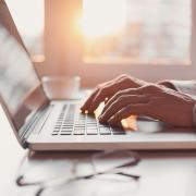 A man types on a laptop keyboard