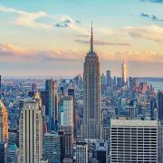 Sunlight illuminates the clouds behind the New York City skyline