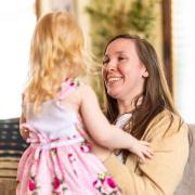 Katy Wuoti smiles and holds her daughter