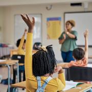 Students raise their hands to answer a question in class