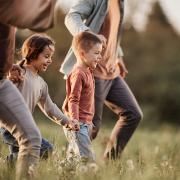 Kids holding hands with their parents in a field