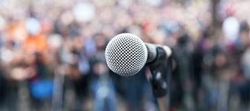 A microphone is seen set up before a crowd