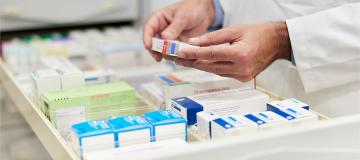 A pharmacist looks at prescriptions in a drawer