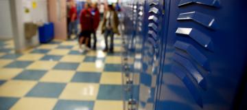 A row of blue lockers lines a school hallway