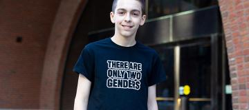 Liam Morrison wearing his "There are only two genders" shirt in front of a courthouse