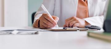 A doctor writes notes on a document