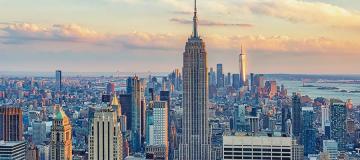 Sunlight illuminates the clouds behind the New York City skyline