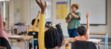 Students raise their hands to answer a question in class