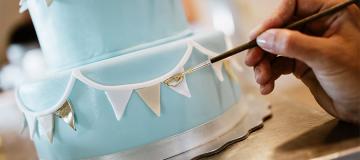 A woman decorates a cake