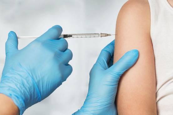 Doctor with gloves giving a vaccine shot