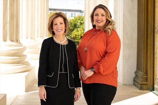 Lorie Smith of 303 Creative and Kristin Waggoner standing in front of the Supreme Court of the United States of America