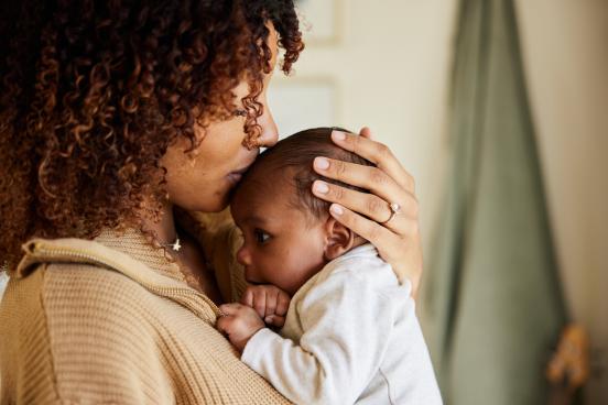 Mother kissing and holding baby