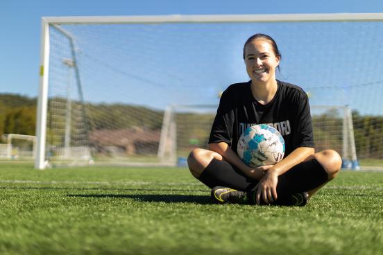 Lainey Armistead sitting with soccer ball