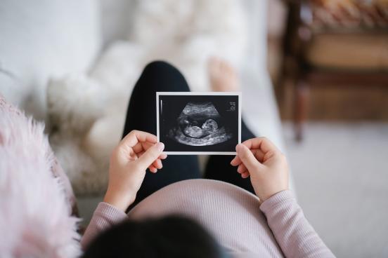 Pregnant mother looking at an ultrasound of her baby