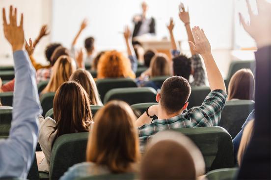 College class with students raising hands